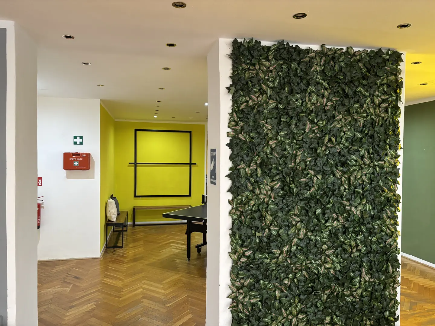 Begrünte Pflanzenwand im Ping Pong Garden Salzburg mit Blick auf den Spielbereich